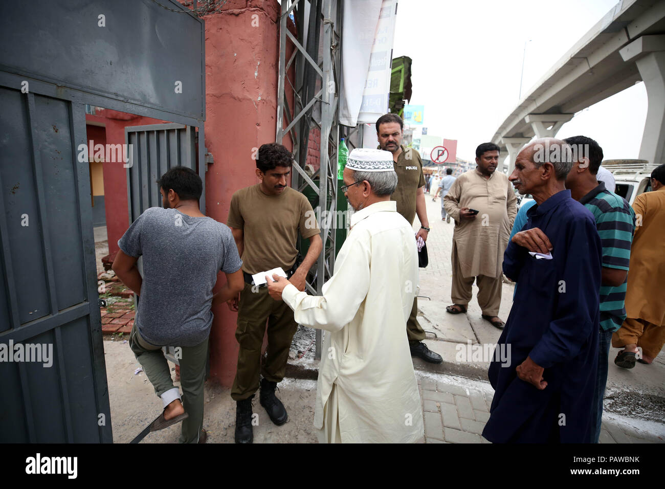 Rawalpindi, Pakistan. 25th July, 2018. People enter a polling station to cast vote during the general elections in Rawalpindi, Pakistan, on July 25, 2018. Pakistan held the general elections on Wednesday. Credit: Ahmad Kamal/Xinhua/Alamy Live News Stock Photo