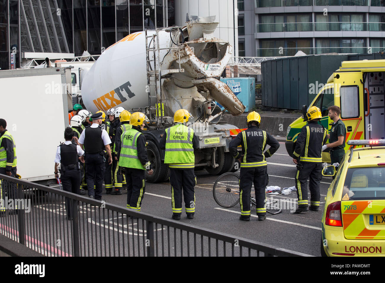 London, UK, 25 July 2018. Old Street Bike accident . 25.07.2018 Emergency services look down at the remains of a cyclists damaged bycycle whilst attending the scene where a cyclist collided with a concrete lorry on Old Street roundabout this afternoon. Credit: Clickpics/Alamy Live News Stock Photo