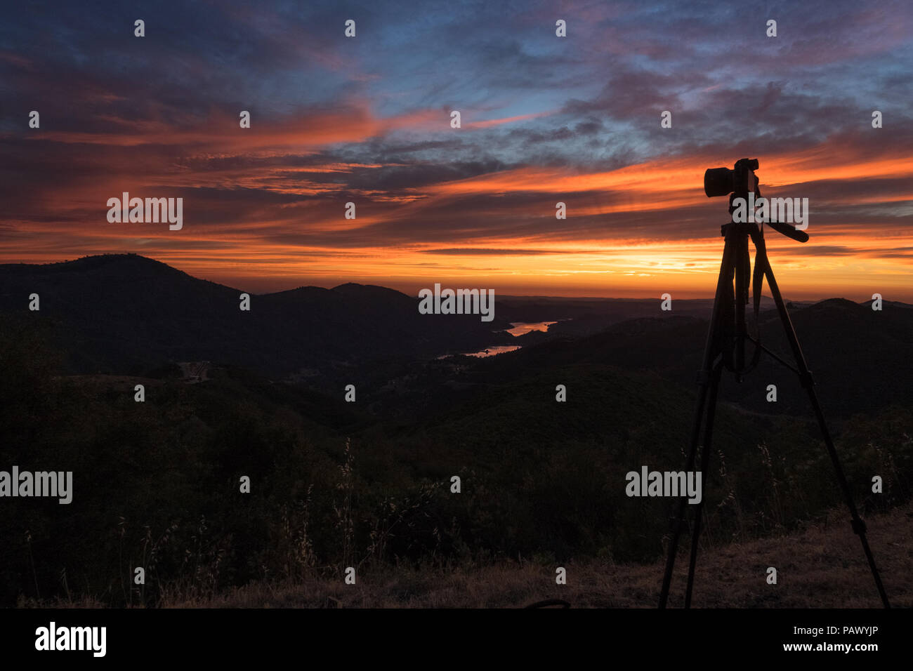 A landscape photographer's tripod and camera posed with incredible  valley sunset - Priest Grade Road - Yosemite Highway 120, California Stock Photo