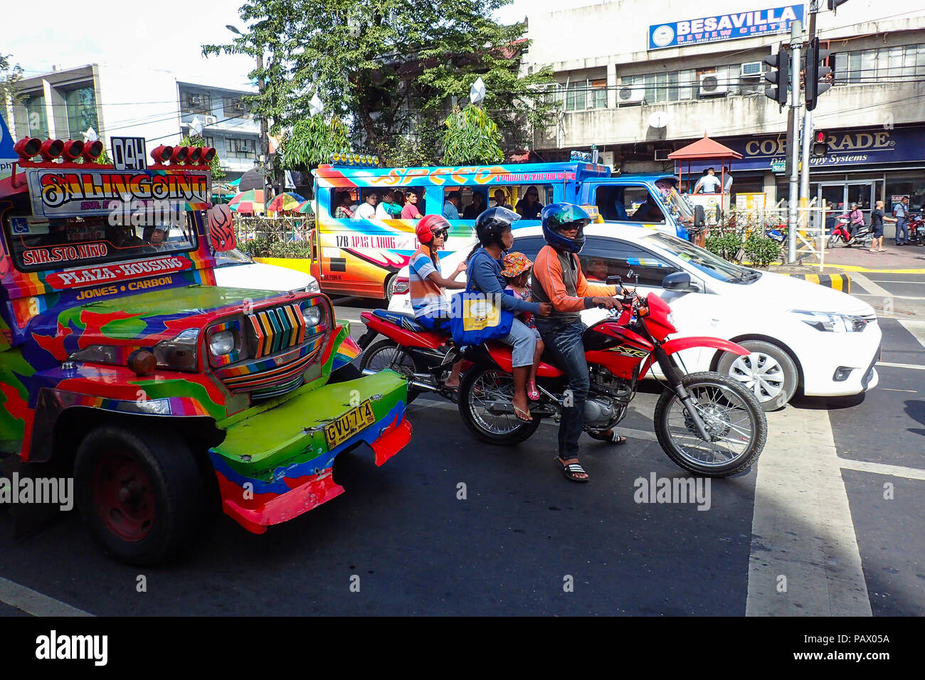 Cebu City, Philippines - January 15, 2015: Bikers wait at traffic light with cars and iconic jeepneys during Sinulog, a large festival each January. Stock Photo