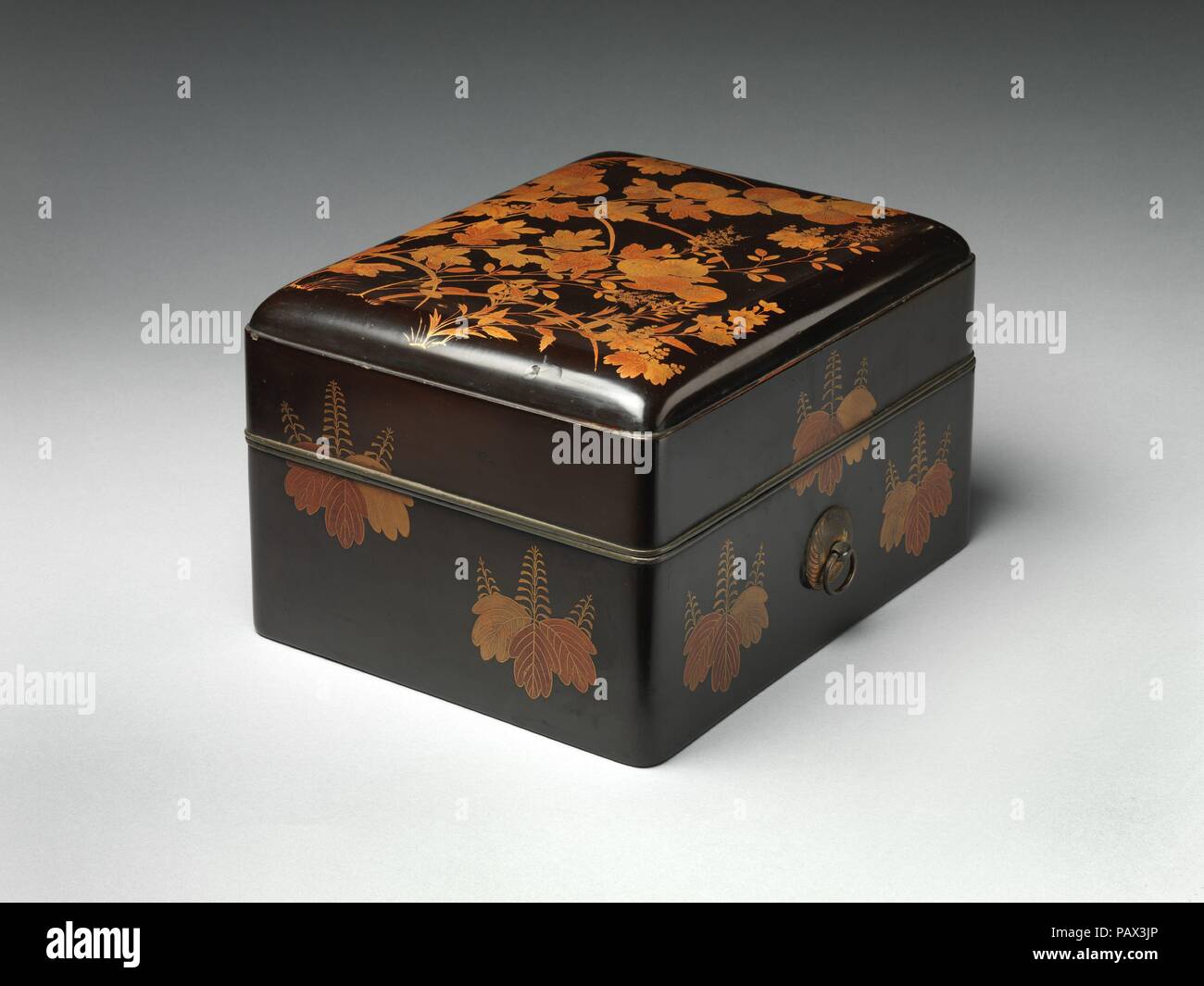 Box for Personal Accessories with Autumn Grasses. Culture: Japan. Dimensions: H. 8 7/8 in. (22.5 cm); W. 8 13/16 in. (22.4 cm); L. 11 1/8 in. (28.3 cm)  Storage Box: 11 x 12 1/4 x 14 1/4 in. (27.9 x 31.1 x 36.2 cm). Date: ca. 1600.  Autumn flowers and grasses, principally chrysanthemums, pampas grass, and bush clover, embellish the lid of this box. Scattered across the naturalistic depiction of these plants are five stylized paulownia crests that echo the larger ones adorning the sides. The combination of such crests with freely rendered autumn grasses is characteristic of lacquers associated  Stock Photo