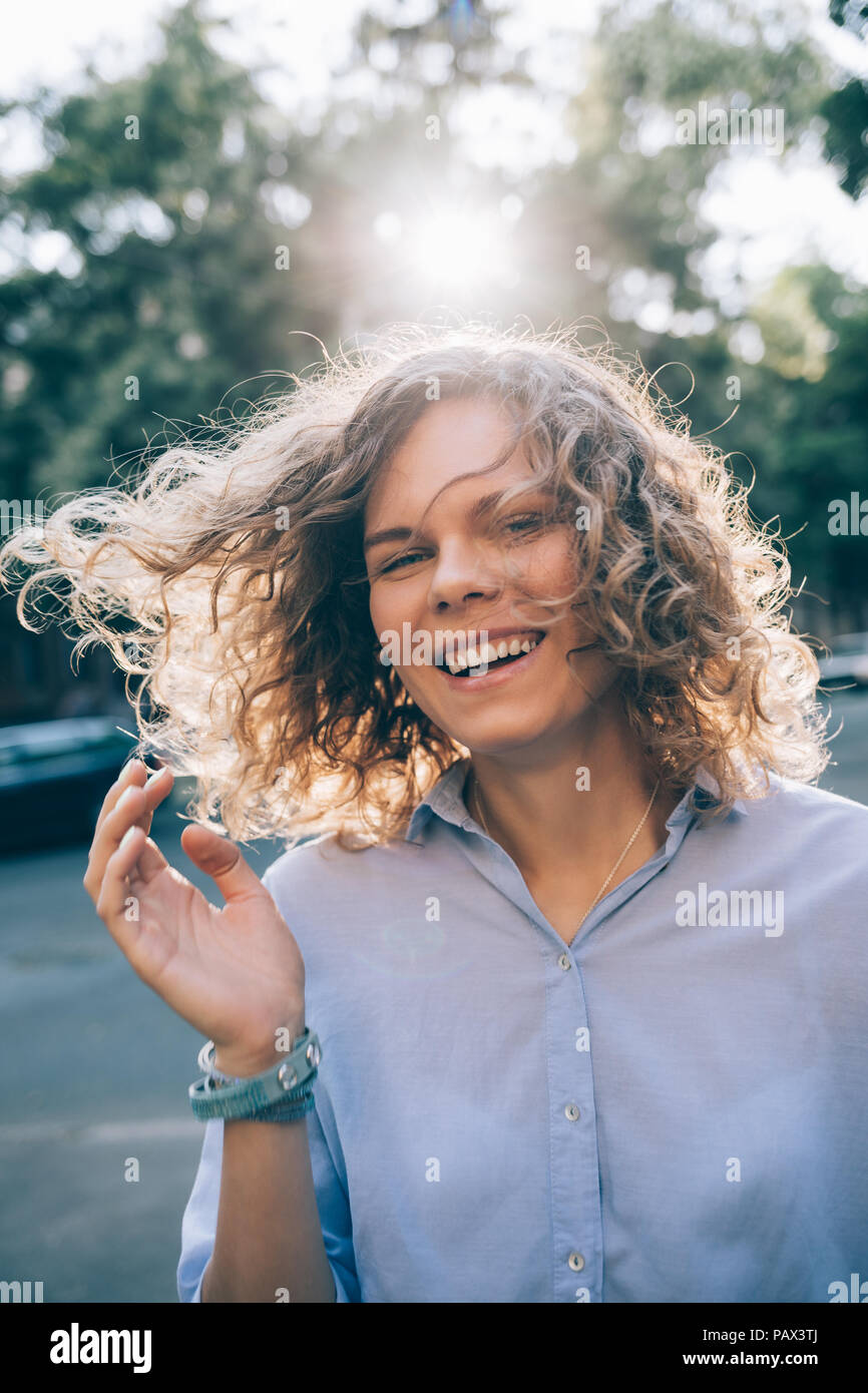 Candid portrait of beautiful young woman laughing in the street on