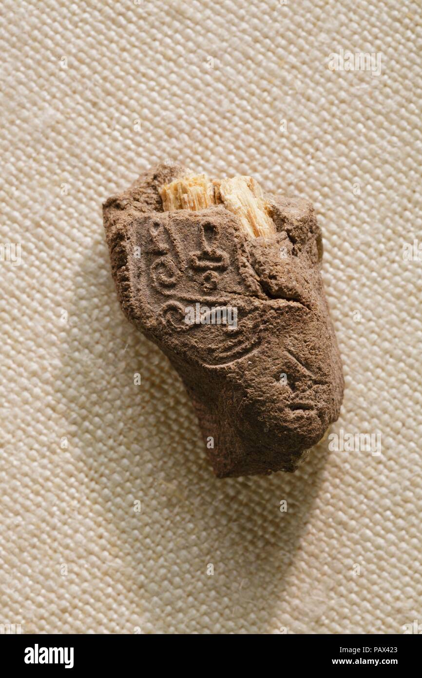Sealing, from letter 22.3.518 from Heqanakht to Rahotep. Dimensions: L. 2 × W. 1.3 cm (13/16 × 1/2 in.). Dynasty: Dynasty 12. Reign: reign of Senwosret I. Date: ca. 1961-1917 B.C..  Discovered attached to a letter from Heqanakht to the Overseer of the Delta, Herunefer (see 22.3.518), this lump of mud is an example of a sealing. When a document was ready, it was folded or rolled and wrapped with a string. A small lump of mud was placed over the ends of the string and impressed with the incised underside of a seal, such as a scarab. This served to identify the owner or writer of the document. Mu Stock Photo