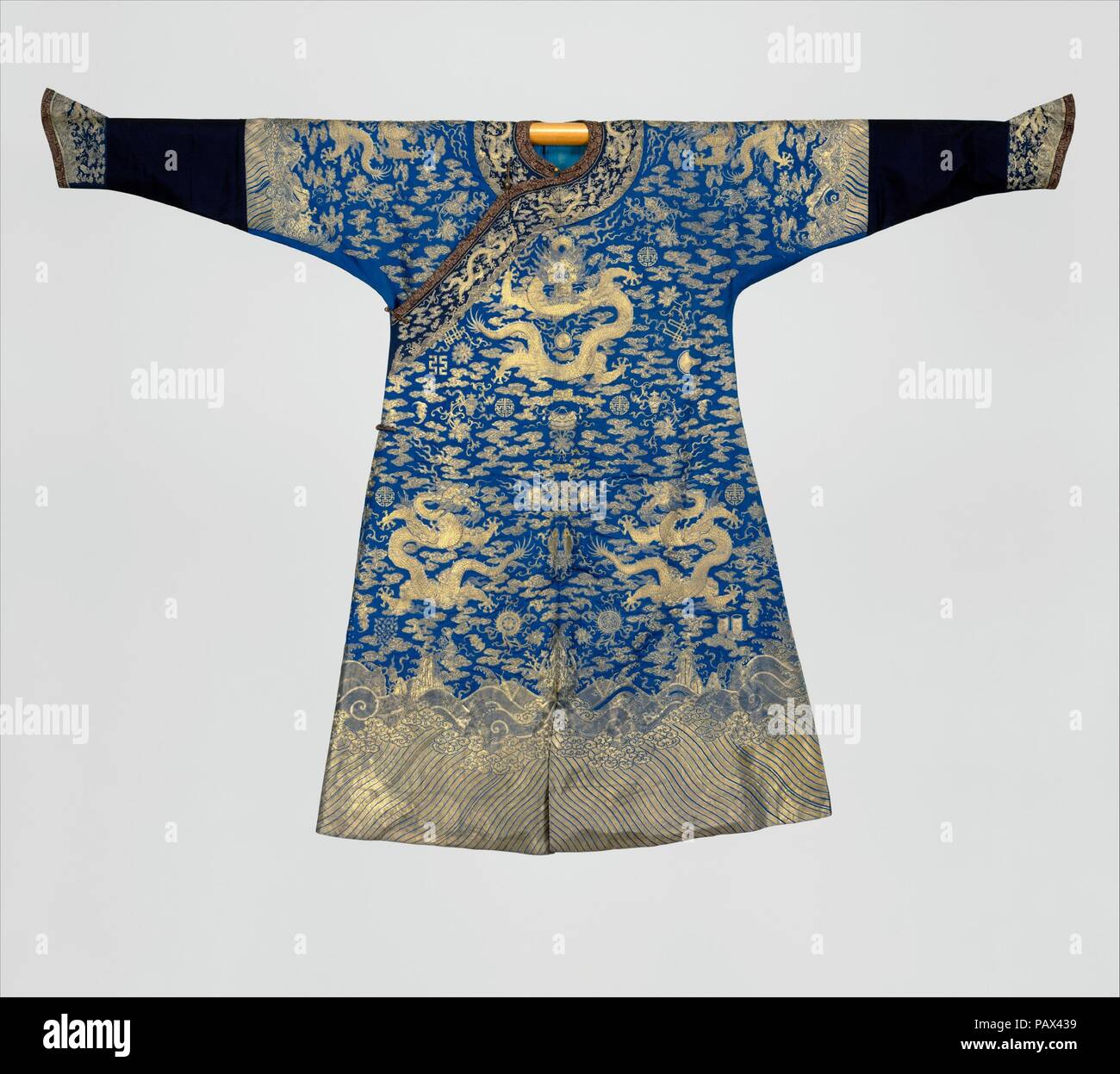 Emperor's twelve-symbol festival robe. Culture: China. Dimensions: Overall: 56 5/8 x 63 1/2 in. (143.8 x 161.3 cm).  Official costumes in imperial China were highly regulated, and the decorative motifs of court outfits were specific to rank. Among the emblems used on the emperor's ceremonial robes were the twelve imperial symbols, as seen on this example: the sun, the moon, constellations, mountains, a pair of dragons, birds, ritual cups, water weeds, millet, fire, an ax, and the symmetrical fu symbol. These symbols, said to have been used since ancient times, represent the emperor's righteous Stock Photo