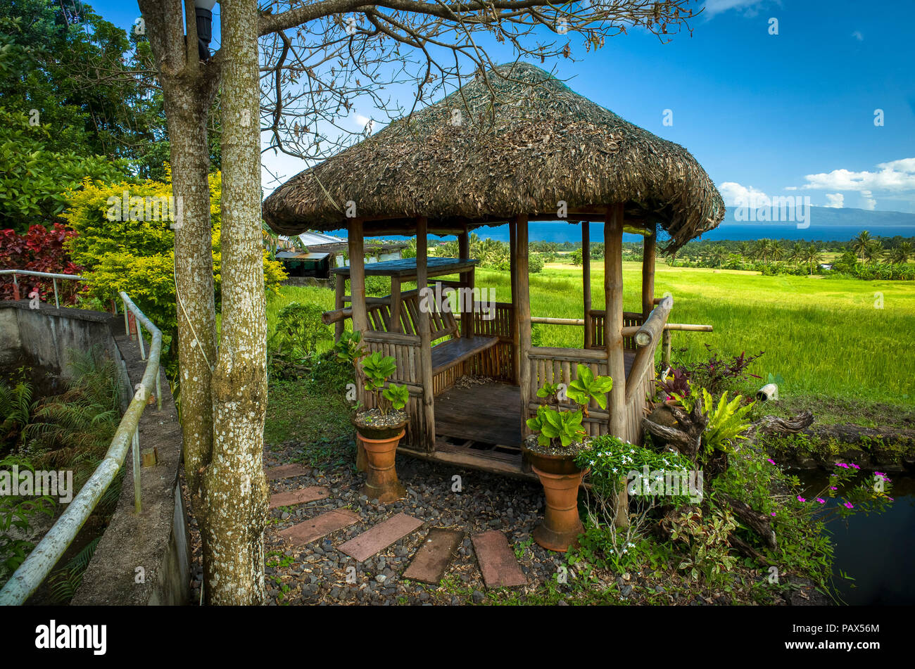 A bamboo hut with seats to shade rice farmers from sun - Albay, Bicol - Philippines Stock Photo