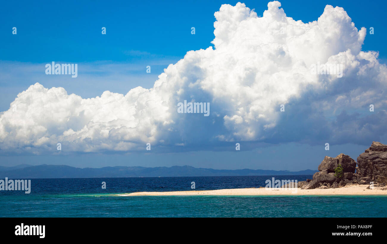 Island Sand bar and rock formation jutting out into the water, With Blue Sky and Cloud Formation Overhead - Puerto Princesa Stock Photo