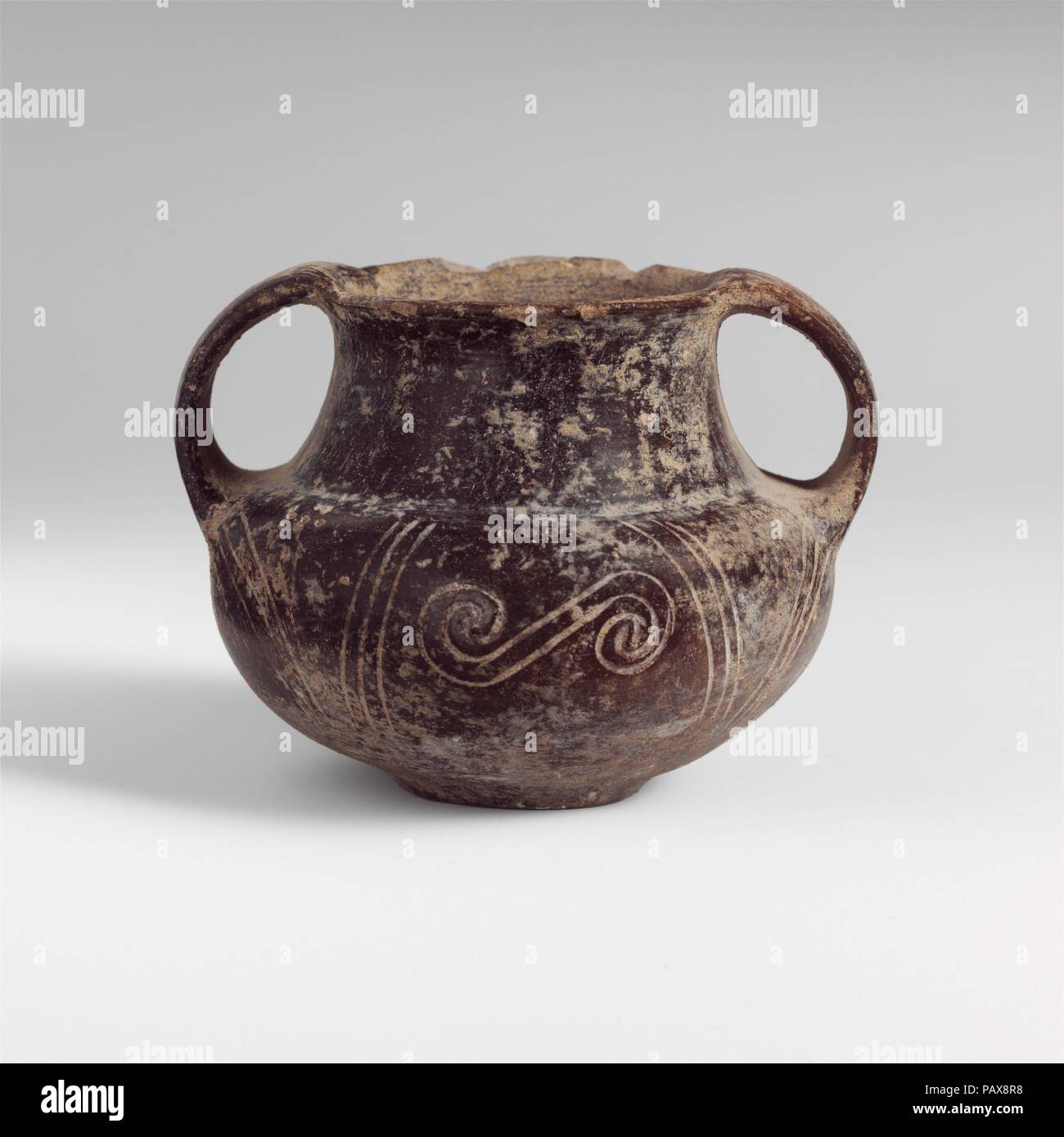 Terracotta two-handled jar. Culture: Italic, Villanovan. Dimensions: H. 2 5/8 in. (6.7 cm). Date: early 7th-mid 7th century BC.  Reddish-brown, two-handled, with incised curvilinear decoration. Museum: Metropolitan Museum of Art, New York, USA. Stock Photo