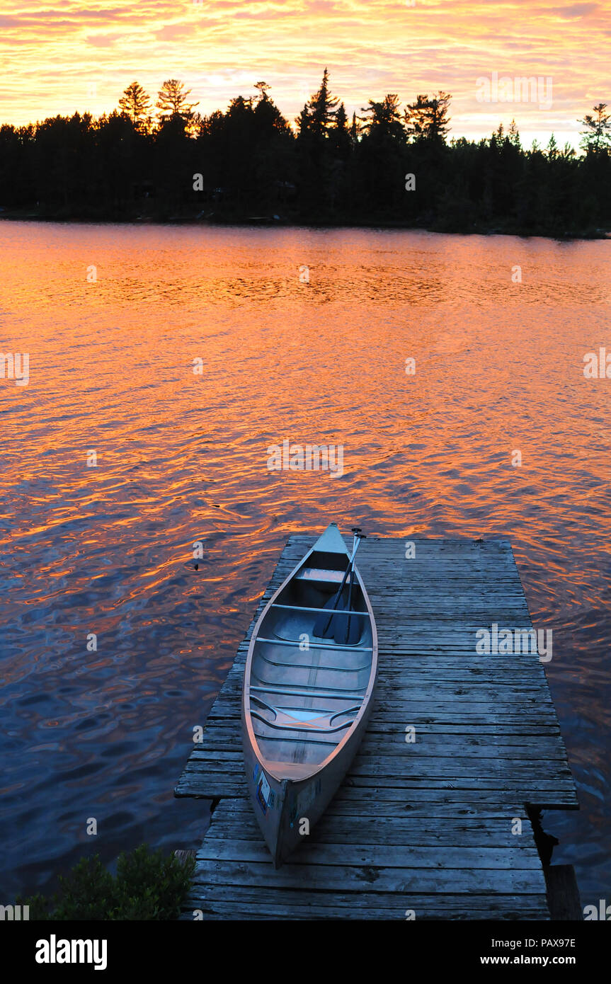 Canoe on dock at sunset sunrise on Lake One in the Boundary Waters