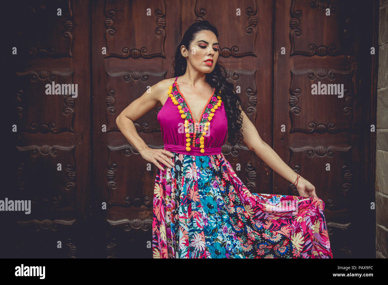 Girl with colorful dress in front of a door Stock Photo - Alamy