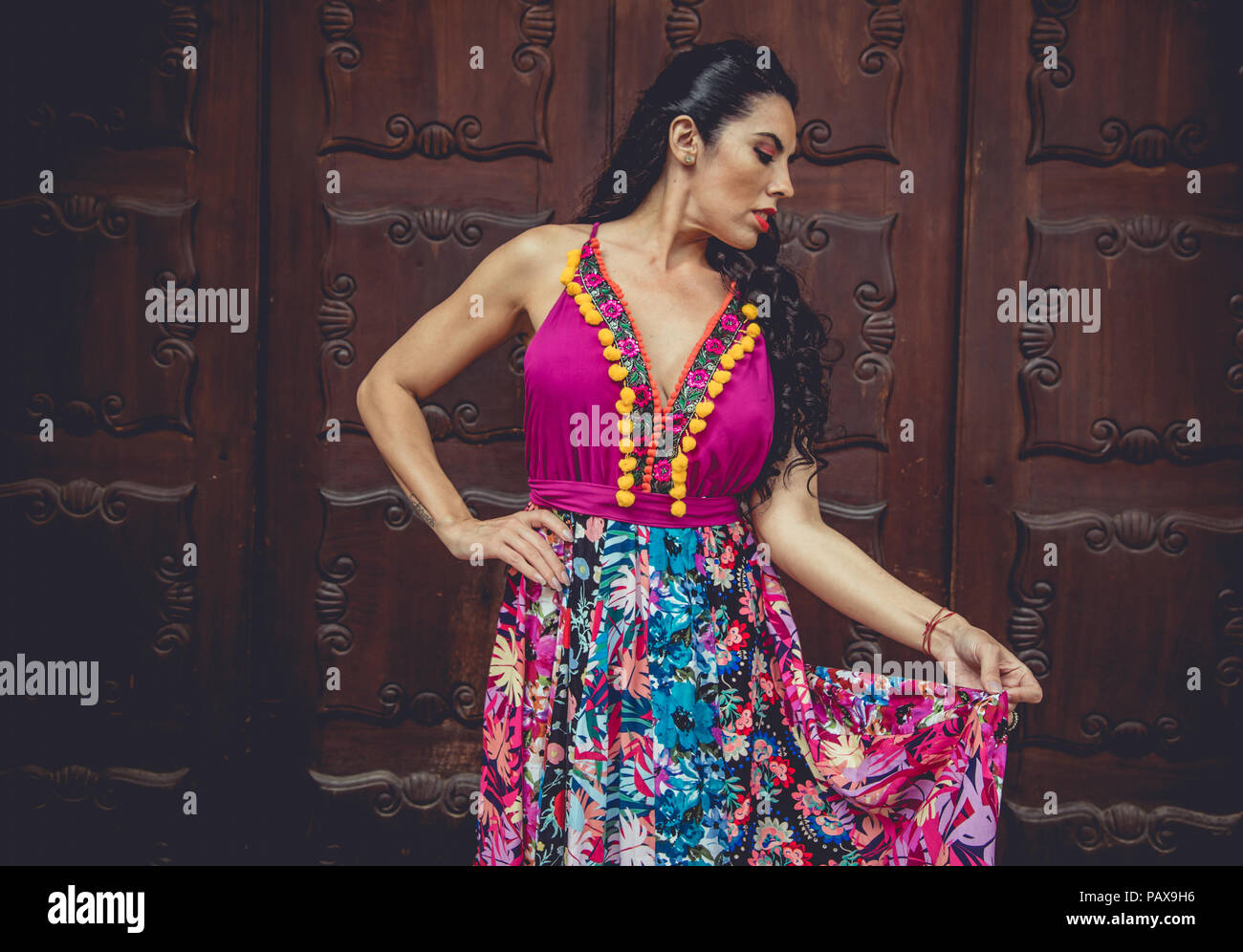 Girl with colorful dress in front of a door Stock Photo - Alamy