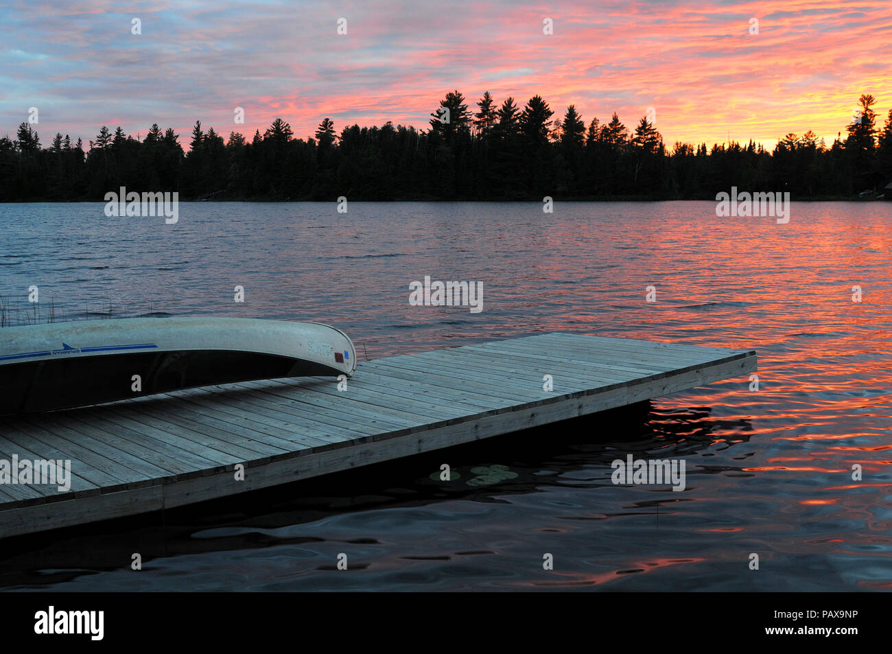 Canoe on dock at sunset sunrise on Lake One in the Boundary Waters