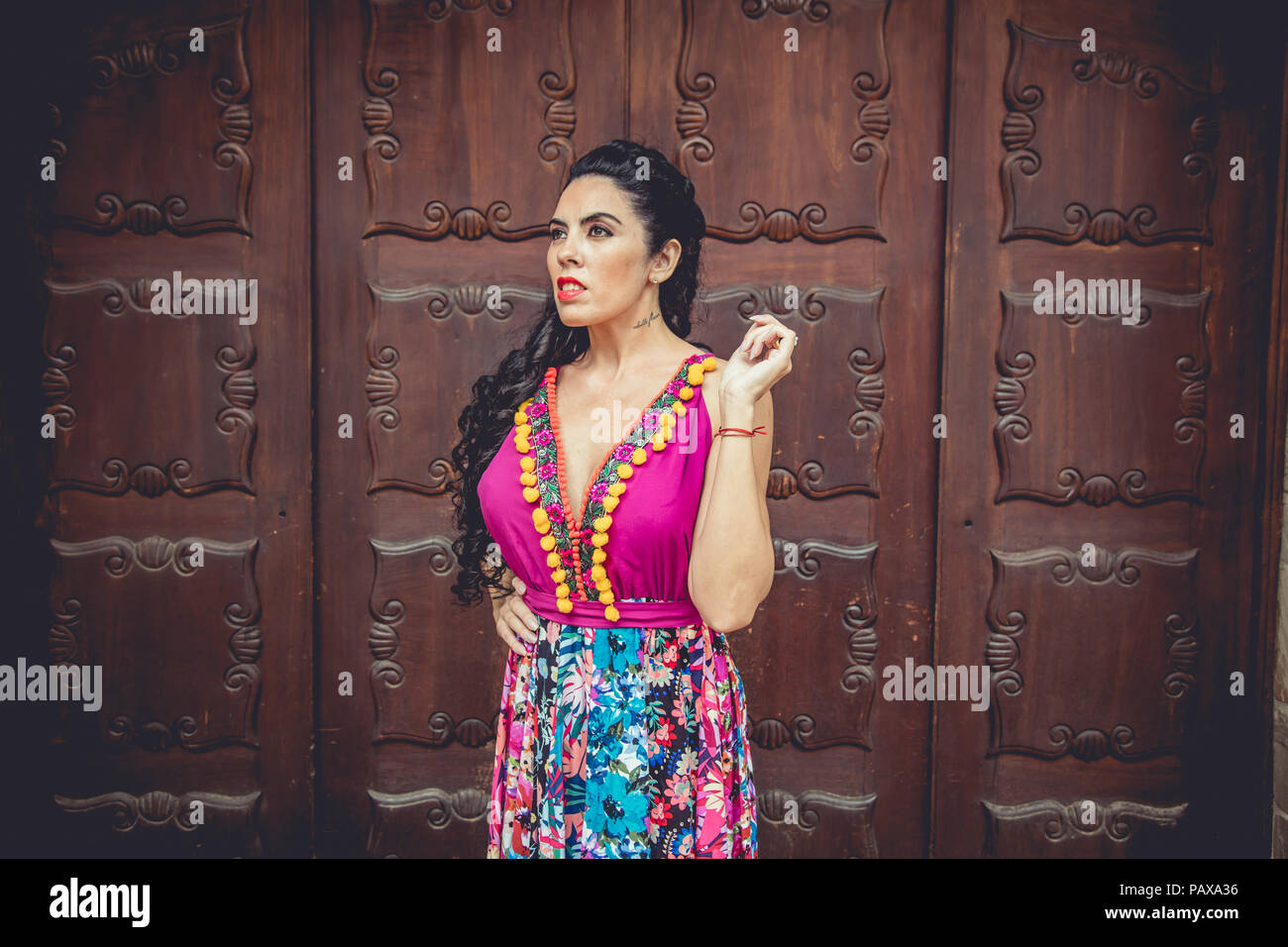 Girl with colorful dress in front of a door Stock Photo - Alamy