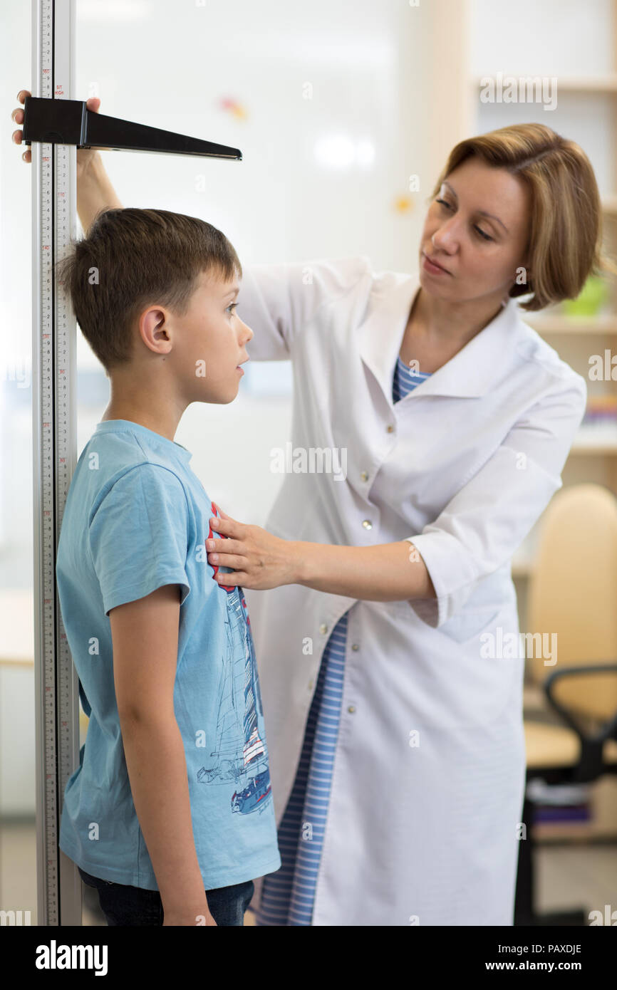 Doctor measures growth child boy in medical office, profile Stock Photo