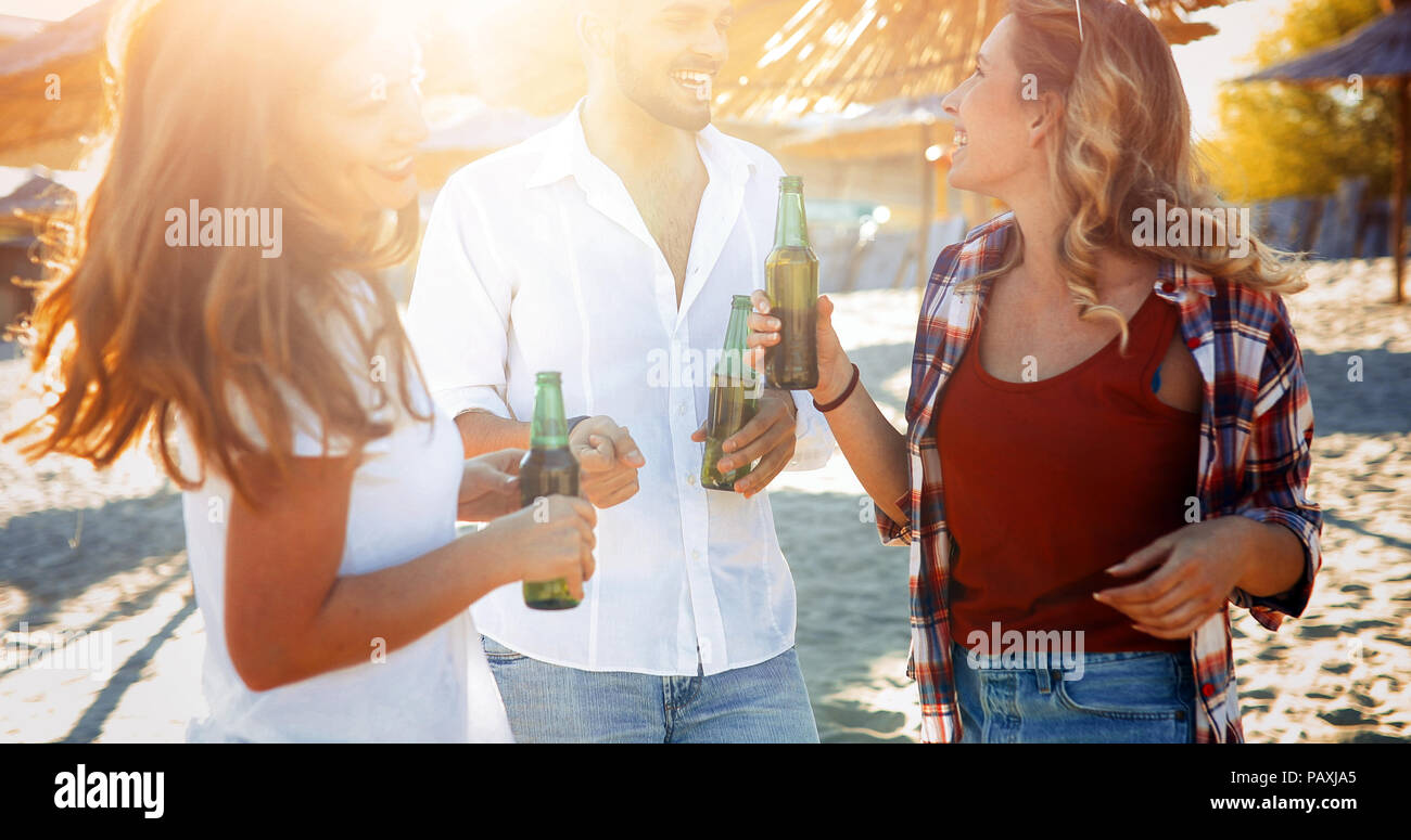 Group of happy friends partying on beach Stock Photo