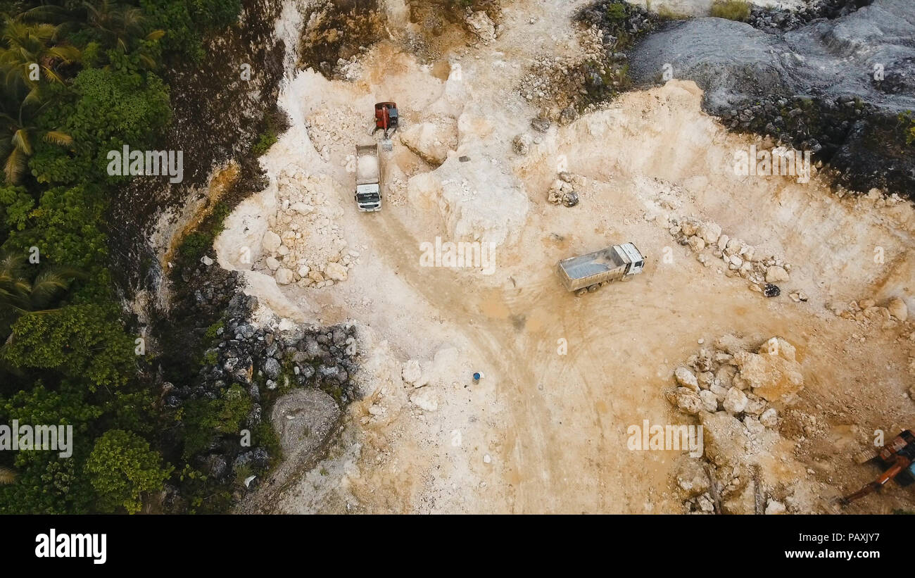 Excavator loads the truck in a limestone quarry. Aerial view wheel