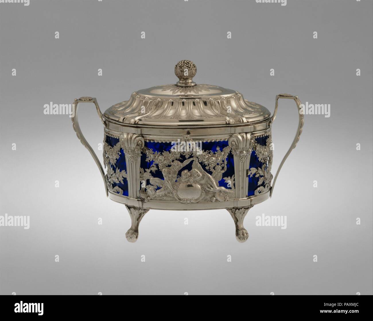 Sugar bowl. Culture: French, Paris. Dimensions: 5 1/4 × 7 in. (13.3 × 17.8 cm). Maker: Marc-Etienne Janety (French, 1739-1820, master 1777). Date: 1786.  Janety appears to have been the first European silversmith to work in platinum, newly available to silversmiths in the 1780s. It had recently been discovered that arsenic lowered the melting point of platinum, allowing it to be cast and then worked. The new medium also had the advantage of not tarnishing. This sugar bowl appears to be the only extant work in platinum by Janety. The crispness of the details, seen in the relief of the satyr and Stock Photo
