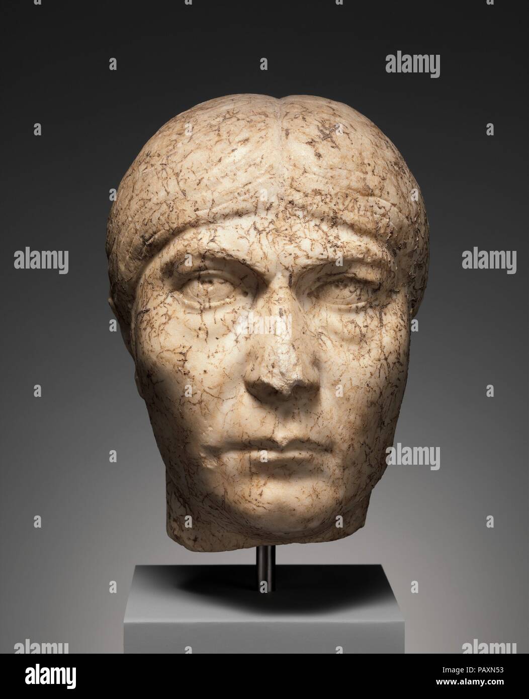 Marble portrait head of a woman. Culture: Roman. Dimensions: Overall: 8 5/8 × 5 3/4 × 6 7/8 in. (21.9 × 14.6 × 17.5 cm). Date: early 3rd century A.D..  The portrait is one of great character, reflecting the personality and physical appearance of the subject. It also illustrates the continuing practice of private individuals of following the fashions set by the imperial court; under the Severan dynasty (A.D. 193-235) hairstyles for both men and women were very restrained in comparison with earlier styles. In addition, the carving at the back of the head indicates that a separate piece of marble Stock Photo