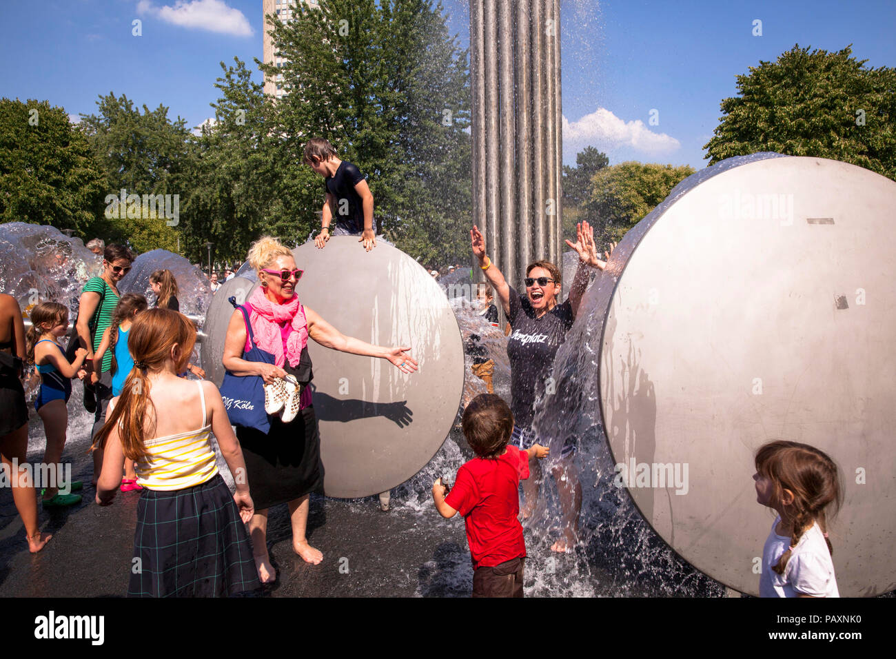 people enjoying the fountain by Wolfgang Goeddertz on the Ebertplatz, Cologne, Germany.  Menschen erfrischen sich am Brunnen von Wolfgang Goeddertz au Stock Photo