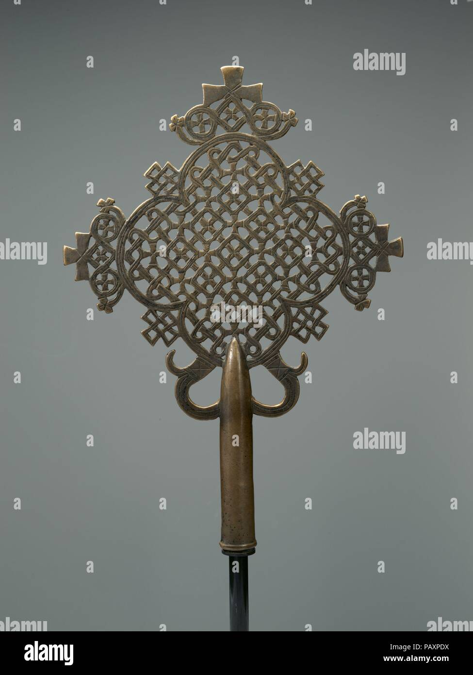 Processional Cross. Culture: Ethiopia, Lasta region. Dimensions: H. 14 x  W. 9 13/16 in. (35.5 x 24.9 cm). Date: early 15th century.  This work is an exceptional example of a popular early 15th century cast copper alloy openwork processional cross developed in Ethiopia -- an art form that has been endlessly reinvented by regional artists. In this example, the ornament is freely worked, while the form is highly symmetrical.    From the time of the adoption of Christianity --  around 330 A.D. --  crosses have been omnipresent not only as liturgical objects in the region's churches and monasterie Stock Photo