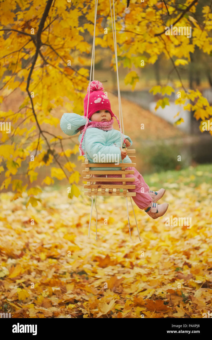 little girl on swings in autumn park Stock Photo - Alamy