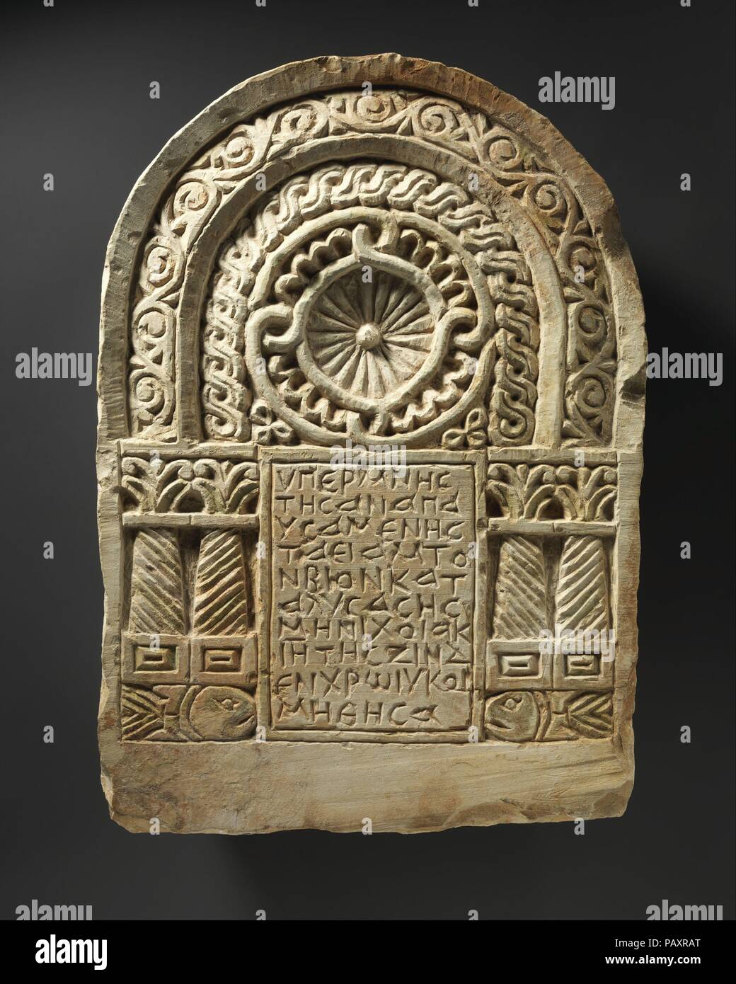 Funerary Stele with Architectural Frame. Dimensions: H. 20 11/16 in. (52.5 cm)  W. 14 9/16 in. (37 cm). Date: 6th-7th century.  Funerary stelae from the Byzantine period in Egypt, carved in stone and usually painted, were permanent monuments to the deceased. While normally embedded in walls or floors near the tomb, some were part of larger structures. Their decorations include scenes of paradise and symbols of the Christian Church. This example, said to be from the Upper Nile Delta town of Armant, bears the name of a prominent citizen who was buried near the marker. Museum: Metropolitan Museum Stock Photo