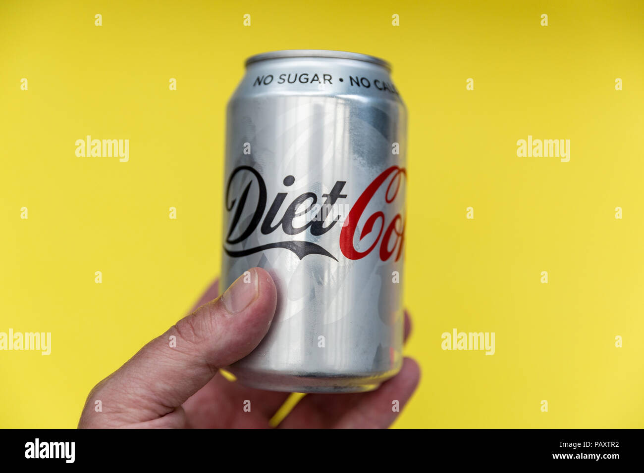 LONDON - July 18, 2018: Can of Diet Coke held on bright yellow background Stock Photo