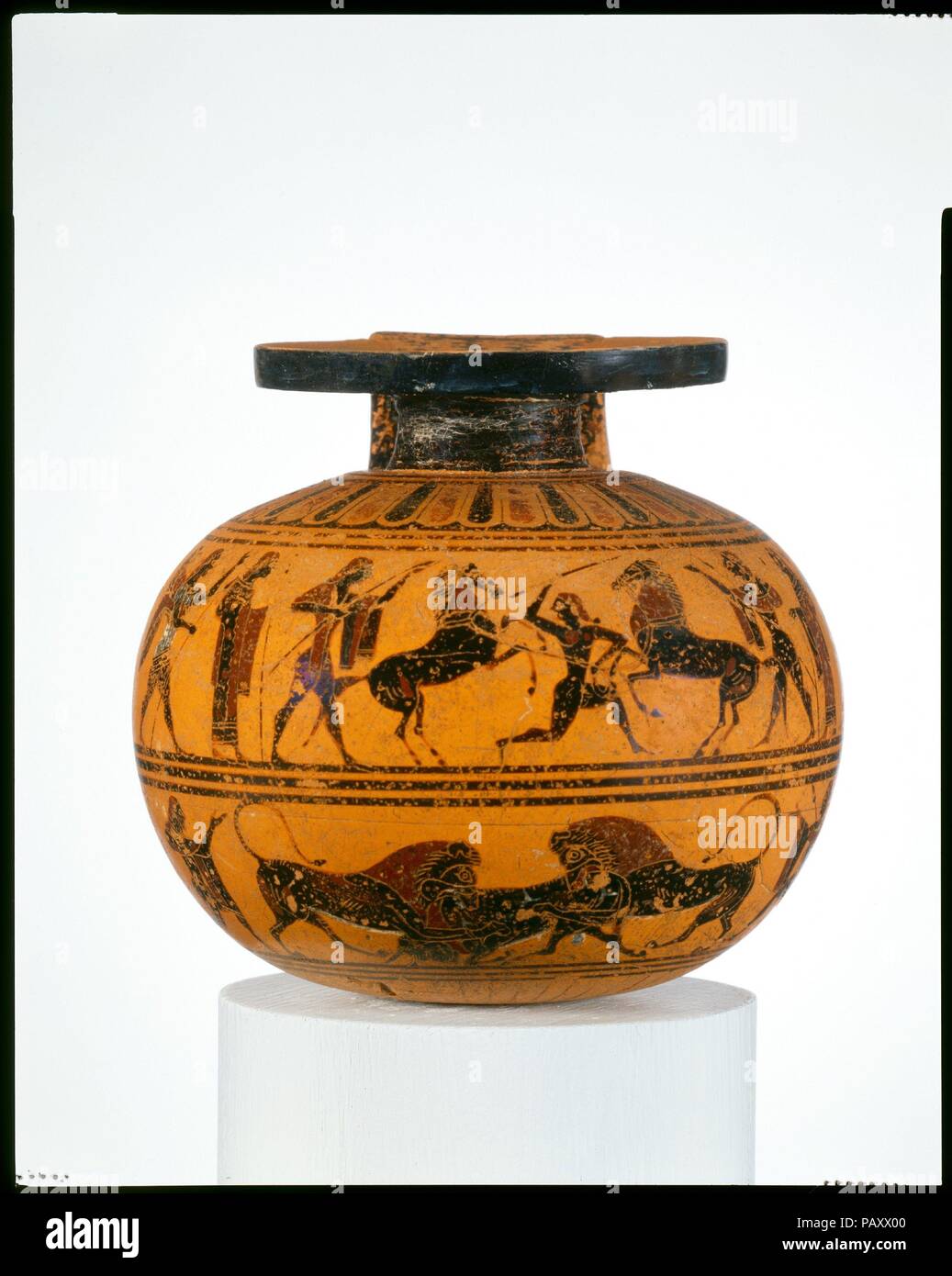 Terracotta aryballos (oil flask). Culture: Greek, Attic. Dimensions: H. 3 1/4 in. (8.3 cm)  diameter  3 1/2 in. (8.9 cm). Date: ca. 550 B.C..  On the handle, Dionysos and two revelers  Upper frieze, horse tamer between onlookers and two wrestlers  Lower frieze, animal combats between onlookers  The aryballos is connected with the gymnasium and the palaistra (exercise ground).  After exercising, men used oil to clean and care for their skin. The subjects here refer to major interests of young Athenians--horses, athletics, and symposia (drinking party). Museum: Metropolitan Museum of Art, New Yo Stock Photo