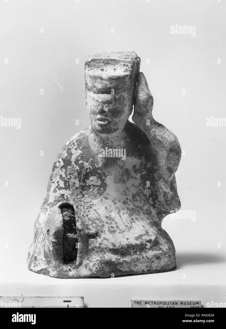 Figure of a Seated Musician. Culture: China. Dimensions: H. 3 1/4 in. (8.3 cm).  The musical instruments depicted among this group of pottery figures (36.12.1, .2, .10-.13, .16) are typical of those used in popular music of the Han period (206 B.C.-A.D. 220). The instruments all had long histories, having existed for centuries, in the case of the zither, or millennia, in the case of the flute (now missing from the figure of the flutist). Museum: Metropolitan Museum of Art, New York, USA. Stock Photo