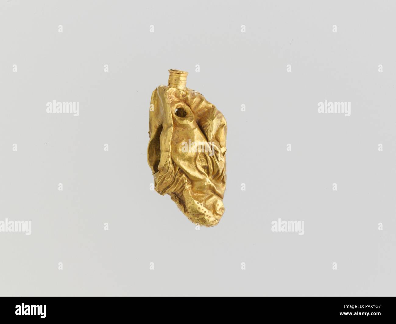 Gold pendant in the form of a bull's head. Culture: Cypriot. Dimensions: L. 13/16 in. (2.1 cm). Date: ca. 1400-1050 B.C..  Pendant in the form of a bull's head. Museum: Metropolitan Museum of Art, New York, USA. Stock Photo