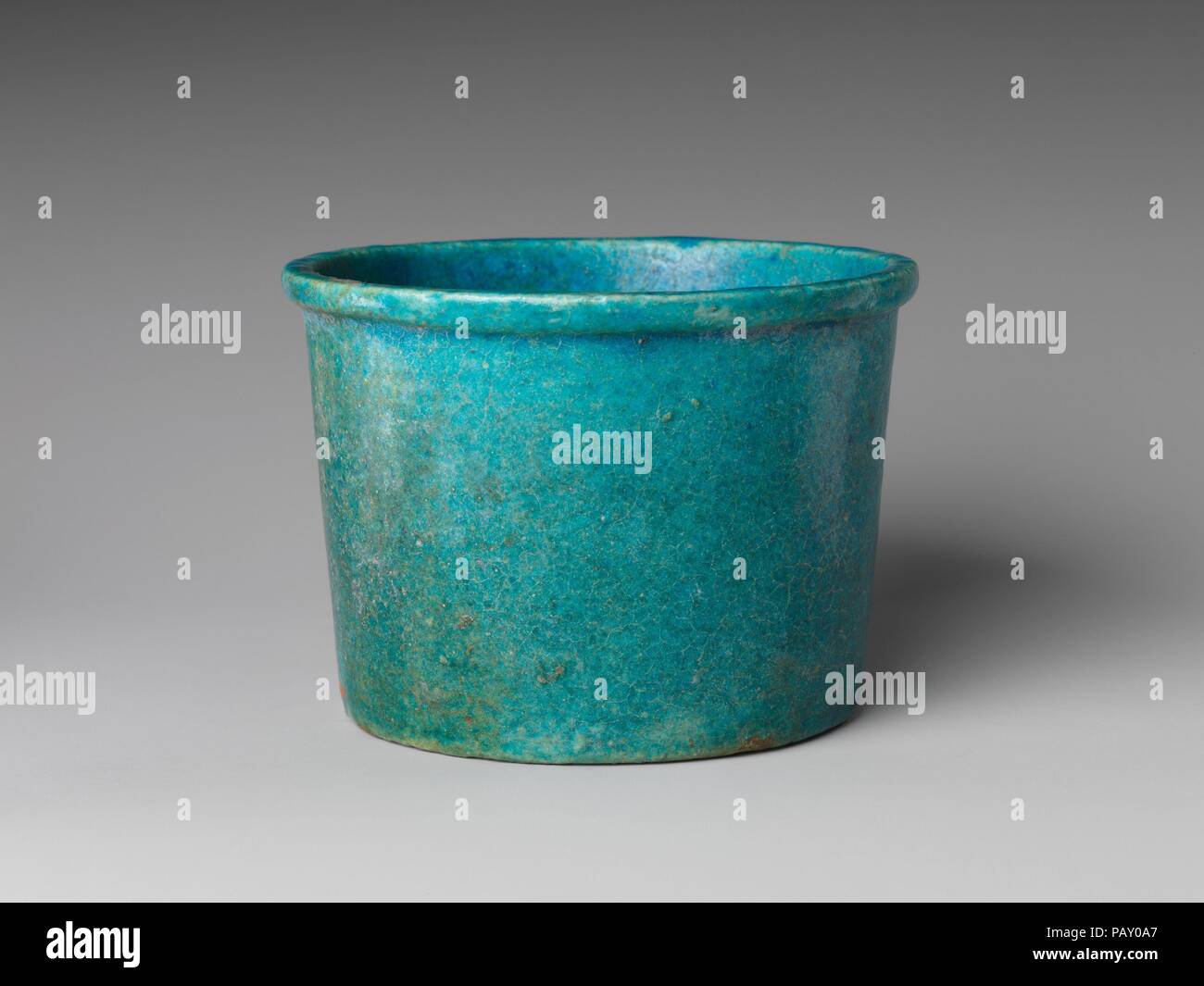 Cup. Dimensions: H. 9.3 x dia. 13 cm (3 11/16 x 5 1/8 in). Date: 500-200 B.C..  Faience cups of this type are frequent in the Late Period. A recent study of faience vessels notes that examples were found in the western dump at the Sacred Animal Necropolis at Saqqara, where datable documents belong to the 5th-4th centuries B.C. The cups vary in size; examples are known that were inscribed and found in sets of 7 for the 7 sacred oils. The type may have continued to be produced during the Graeco-Roman period, but the quality of the glaze here - very thick and most often with craquelure in a regul Stock Photo