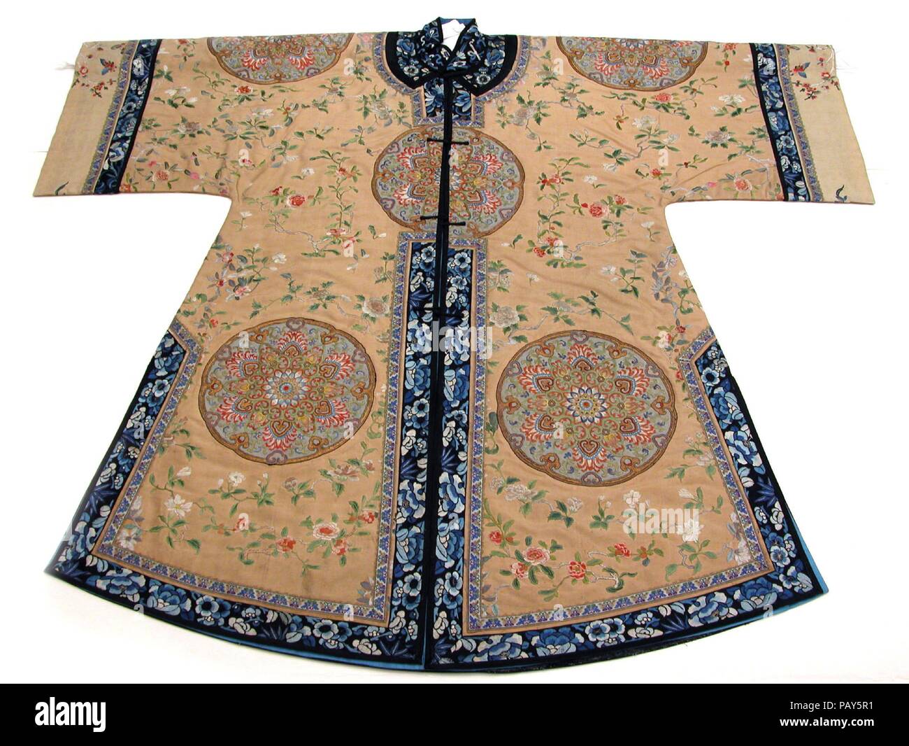 Woman's Informal Coat with Large Rosettes. Culture: China. Dimensions: Overall: 44 x 52 in. (111.8 x 132.1cm). Date: 18th century.  Roundels and rosettes have a long history in China, dating back to the seventh century. The embroidered rosettes on this robe are particularly notable for their fine detail. They are on a nearly hidden light-blue background and were set in, not applied to the surface of the garment, which features a subtly contrasting light-golden-yellow background embroidered with flowering branches. Exquisite robes such as this one were often refurbished for succeeding generatio Stock Photo