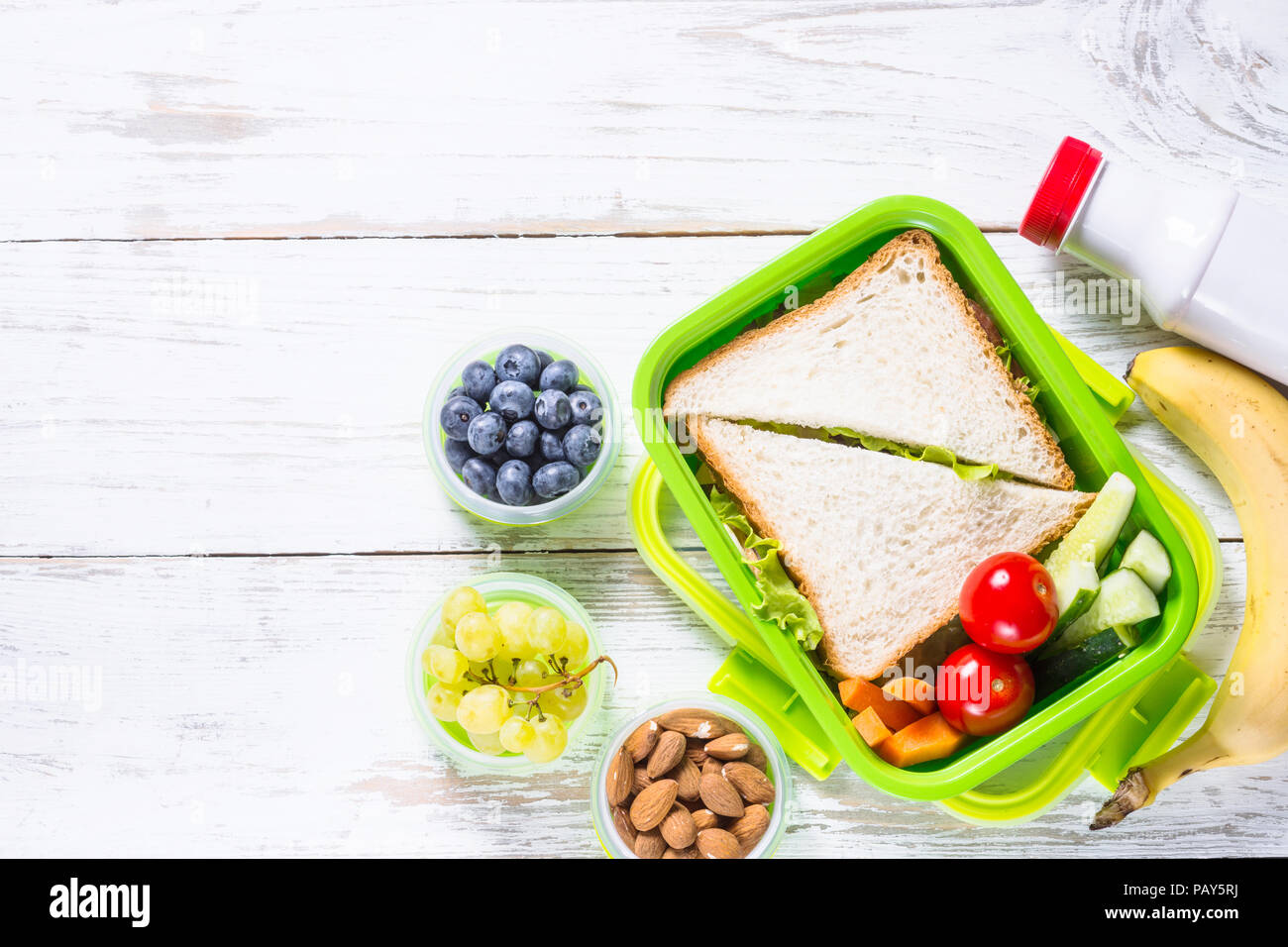 Lunch box with sandwich, vegetables, yogurt, nuts and berries Stock