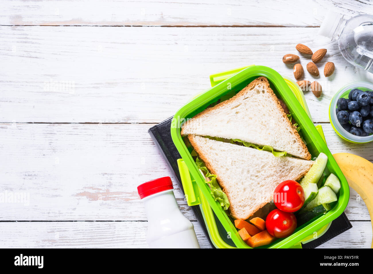 Lunch box with sandwich, vegetables, yogurt, nuts and berries Stock
