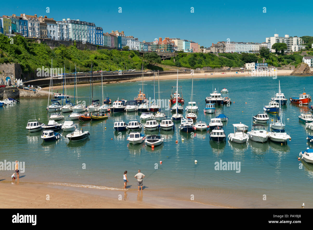 The pretty seaside town of Tenby, Pembrokeshire, Wales, UK. Leisure boats are pictured in the harbour against a backdrop of The North Beach and cliff. Stock Photo