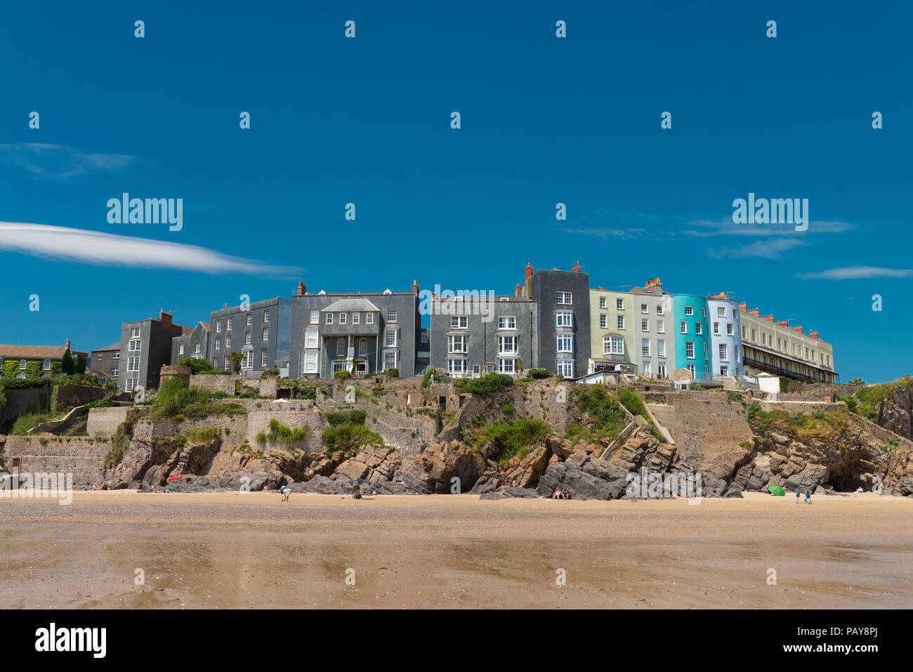 Under a blue summer sky hotels and houses sit on the cliff overlooking South Beach in the pretty seaside town of Tenby, Pembrokeshire, Wales, UK. © Ro Stock Photo