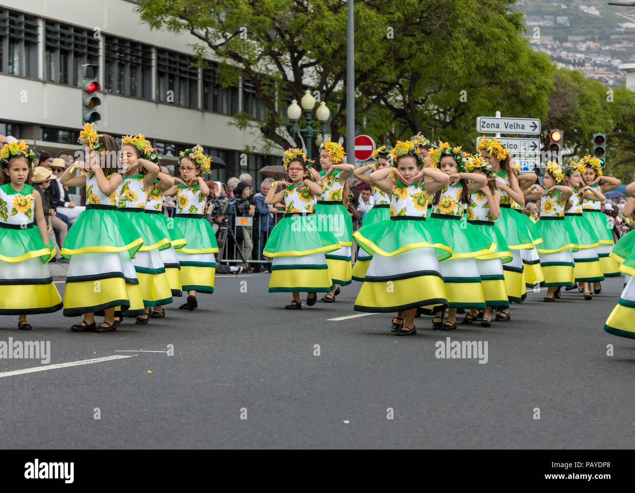 Funchal; Madeira; Portugal - April 22; 2018: A group of girls in colorful dresses are dancing at Madeira Flower Festival Parade in Funchal on the Isla Stock Photo
