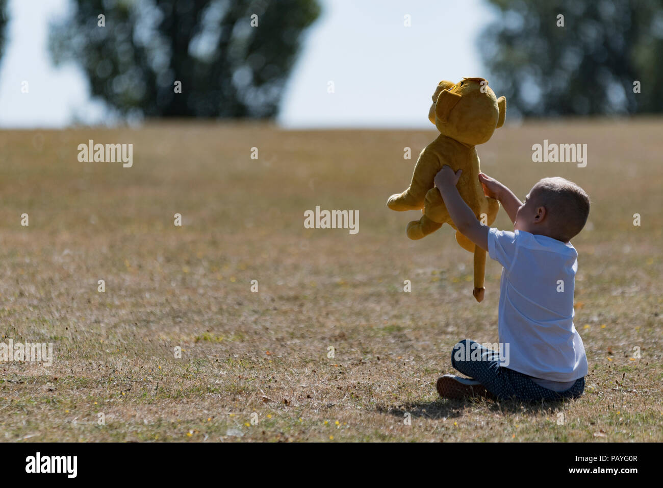 Child with Plush toy in park Stock Photo