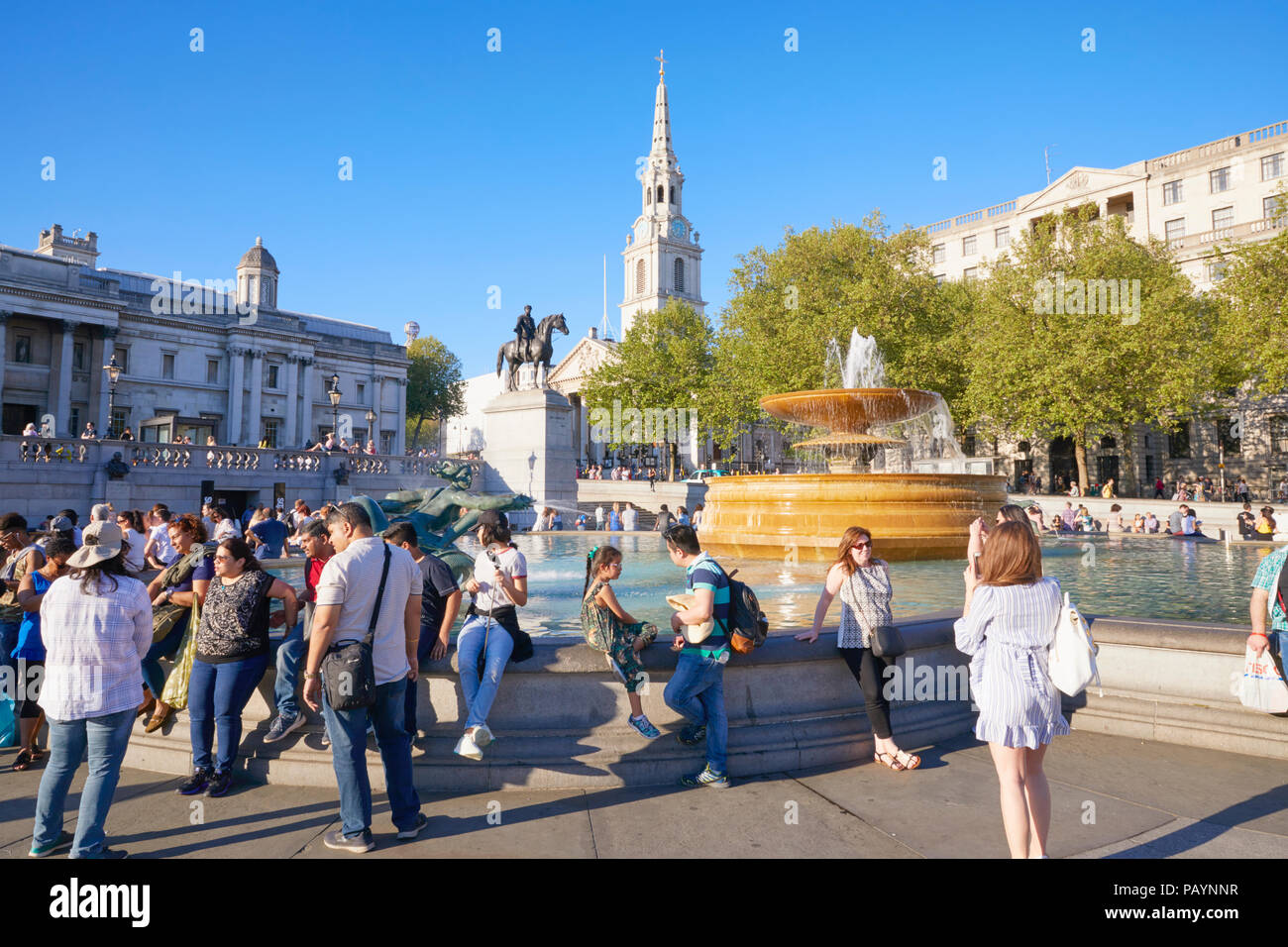People enjoying sun shine in Trafalgar Square, Whitehall, London, England Stock Photo