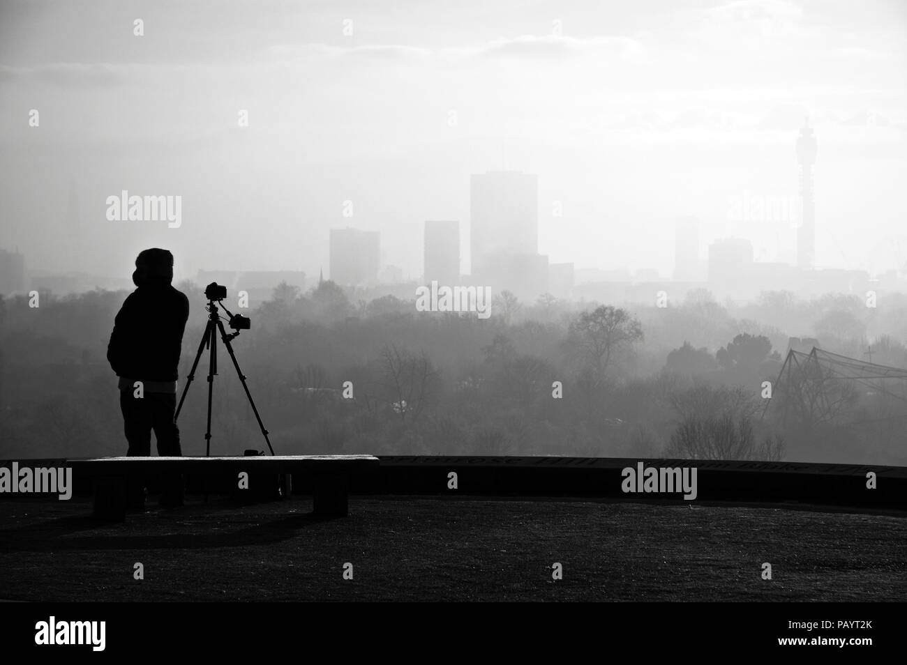 Lone photographer photographing the distant murky city skyline from the