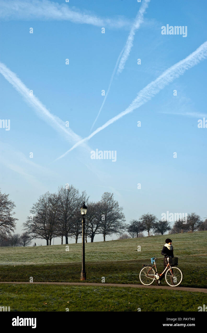 Woman pushing bike through Primrose Hill Park on a frosty day in the