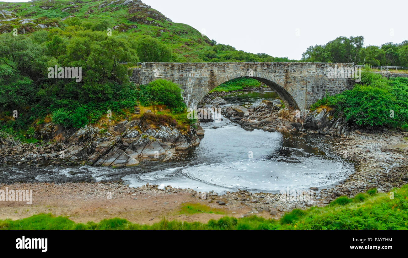 Ancient stone bridge in the Highlands of Scotland - typical scenery Stock Photo