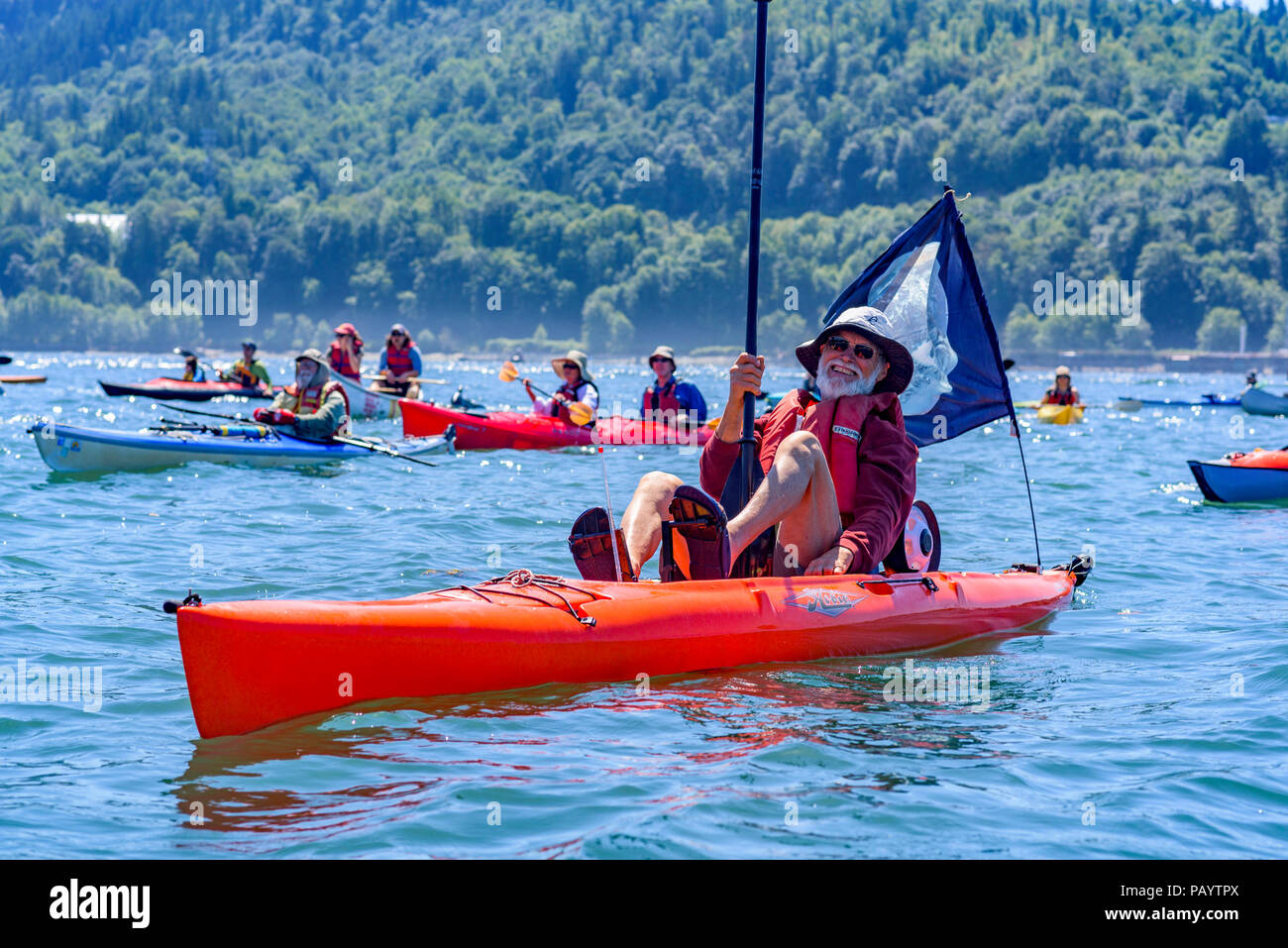 A flotilla of kayakers and Coast Salish canoes protest against the