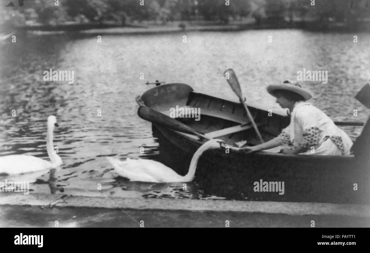 Helen Keller, half-length portrait, facing left, sitting in boat feeding swan, circa 1913 Stock Photo