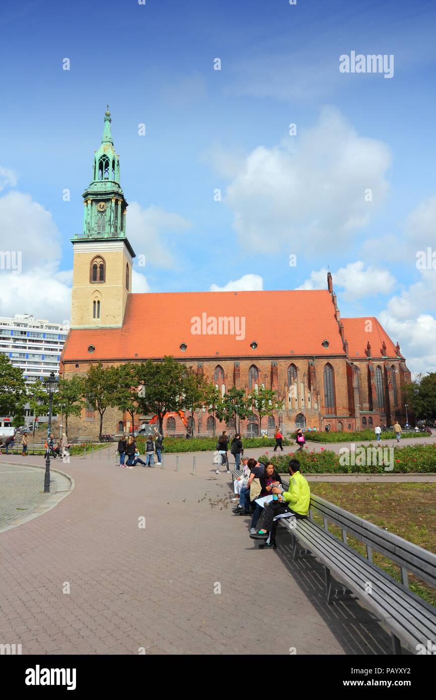 BERLIN, GERMANY - AUGUST 26, 2014: People walk by Saint Mary's Church in Berlin. Berlin is Germany's largest city with population of 3.5 million. Stock Photo