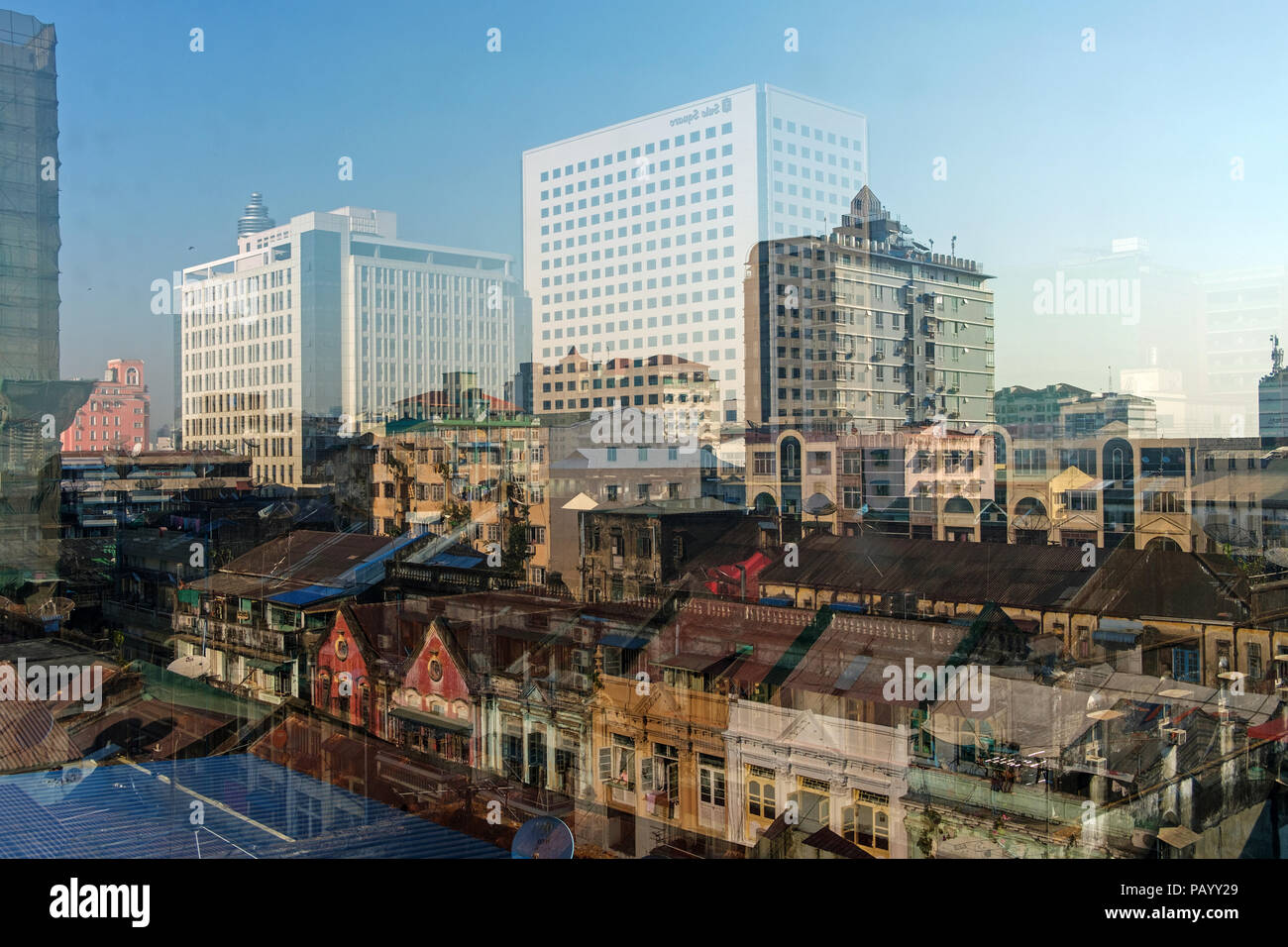 A reflection in a window of the new and colonial builidings in the Downtown of Yangon, Myanmar. Stock Photo