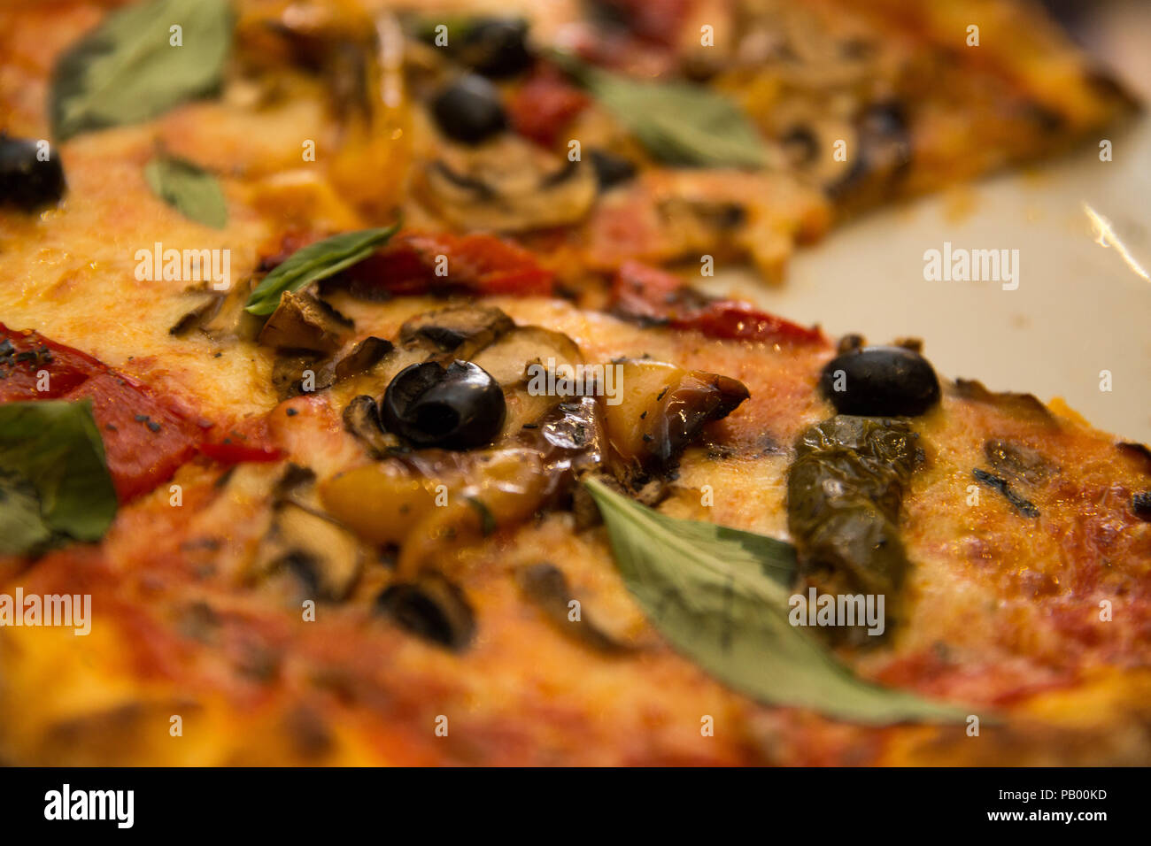 Close up of a pizza with a slice missing Stock Photo