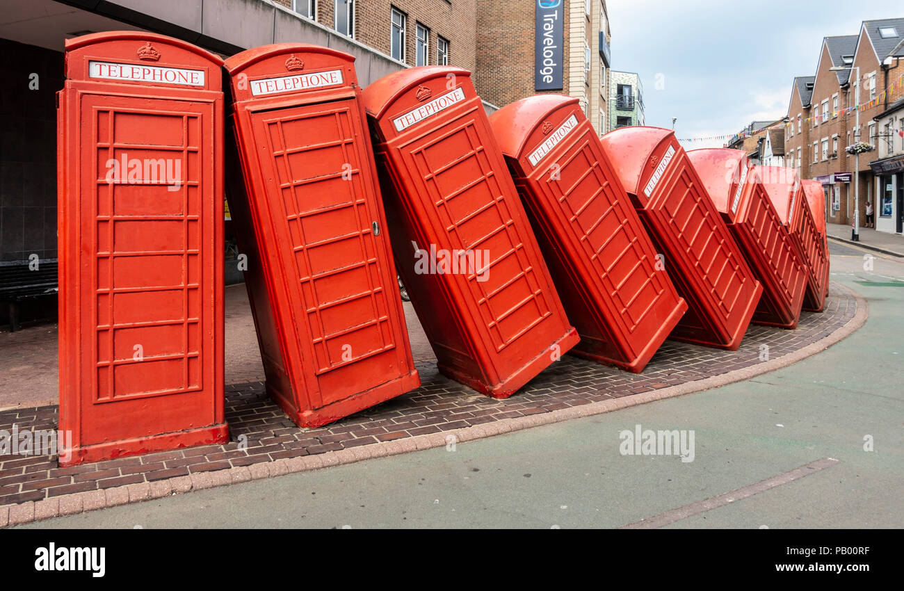 Part of David Mach's art installation 'Out of Order' (1989) featuring falling over traditional red telephone boxes, in Kingston Upon Thames, England Stock Photo