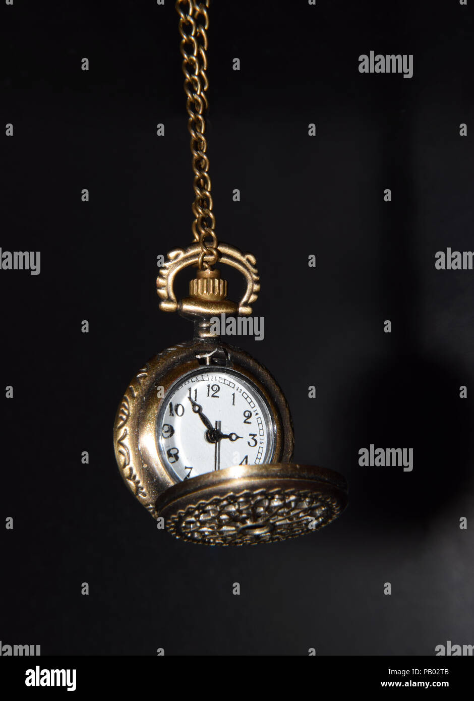 Swinging Opened Vintage Pocket Watch on Black Background Isolated