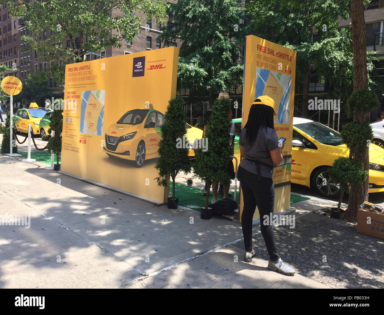 The DHL Formula E Eprix eShuttle promotion in the Greenwich Village neighborhood of New York on Friday, July 13, 2018. DHL's promotion, as part of their sponsorship of the Formual E Eprix electric racing car race, is offering free eShuttle rides in their fleet of Nissan Leafs. (Â© Frances M. Roberts) Stock Photo