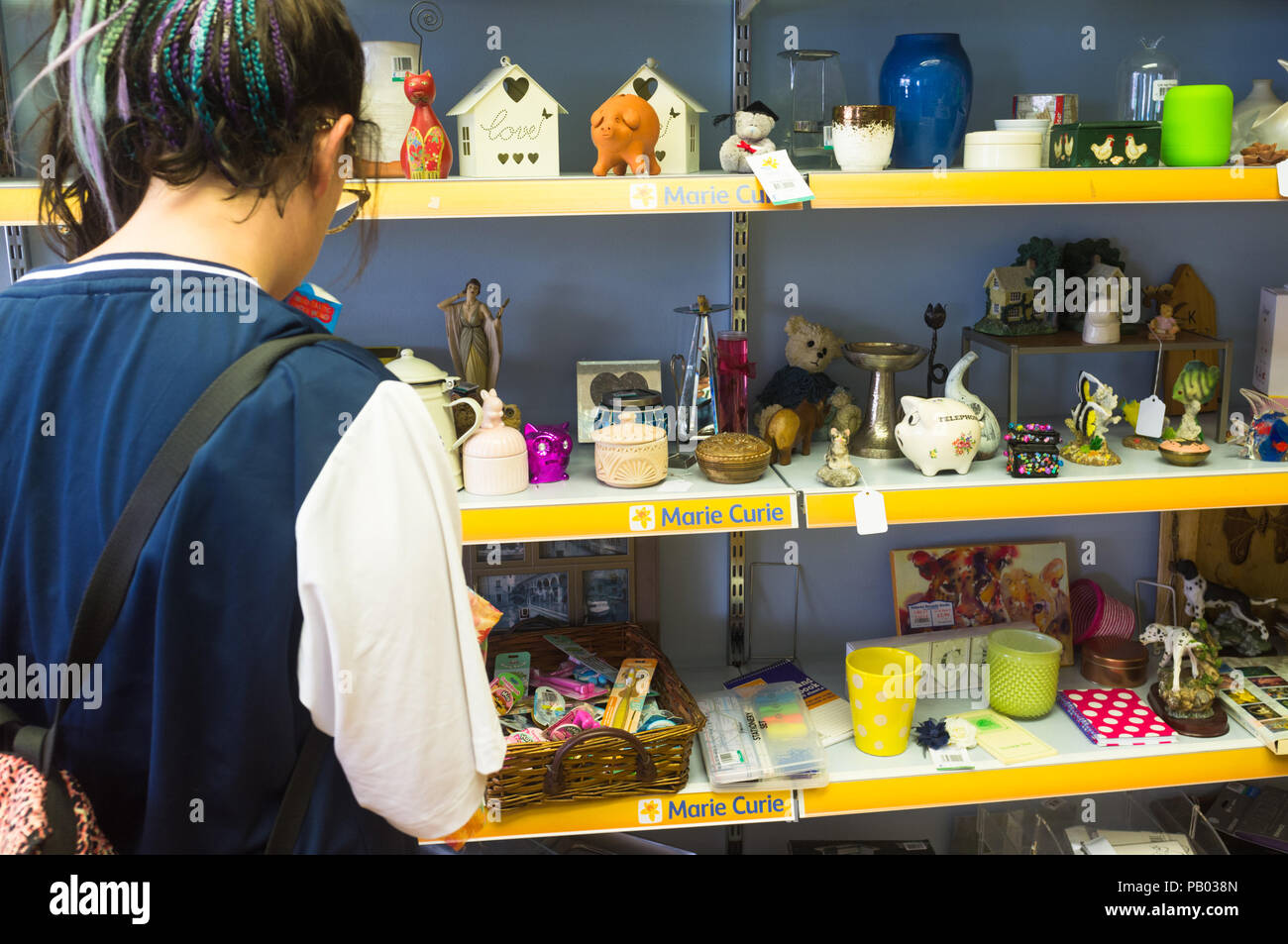 Young woman pictured browsing inside a UK charity shop Marie Curie Stock Photo Alamy
